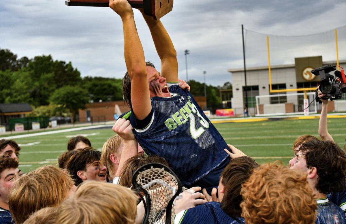 The Lucy Beckham Boys Lacrosse team lifts their trophy in triumph after securing their third consecutive state championship title.